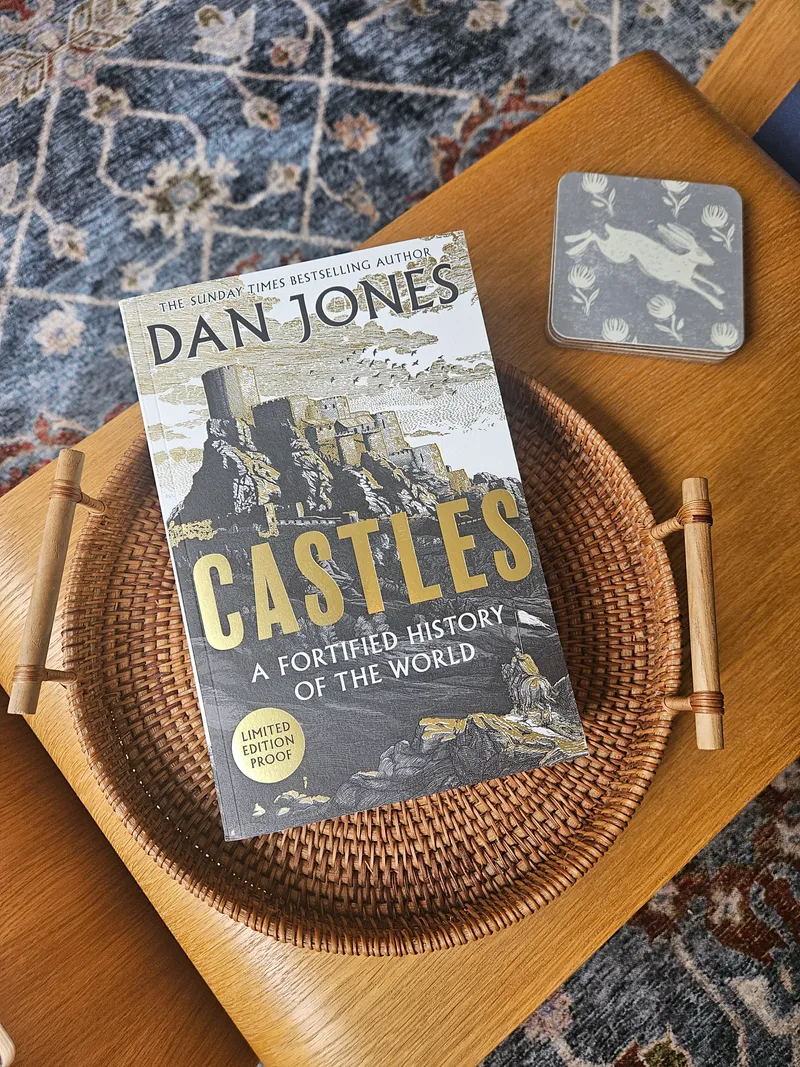 Julia holding a copy of Castles: A Fortified History of the World by Dan Jones