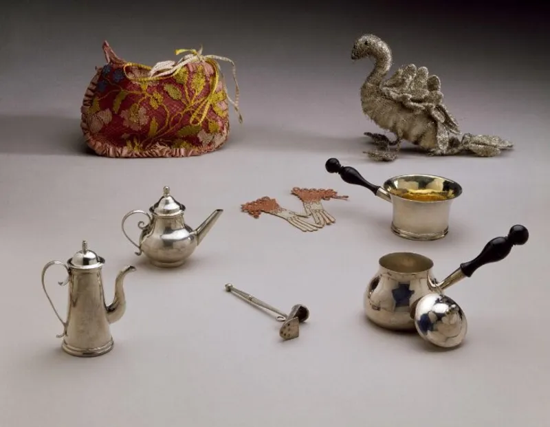 A collection of 17th-century toys, including miniature kitchen utensils and decorative items, showcasing the intricate craftsmanship of the period. Credit: Victoria and Albert Museum.