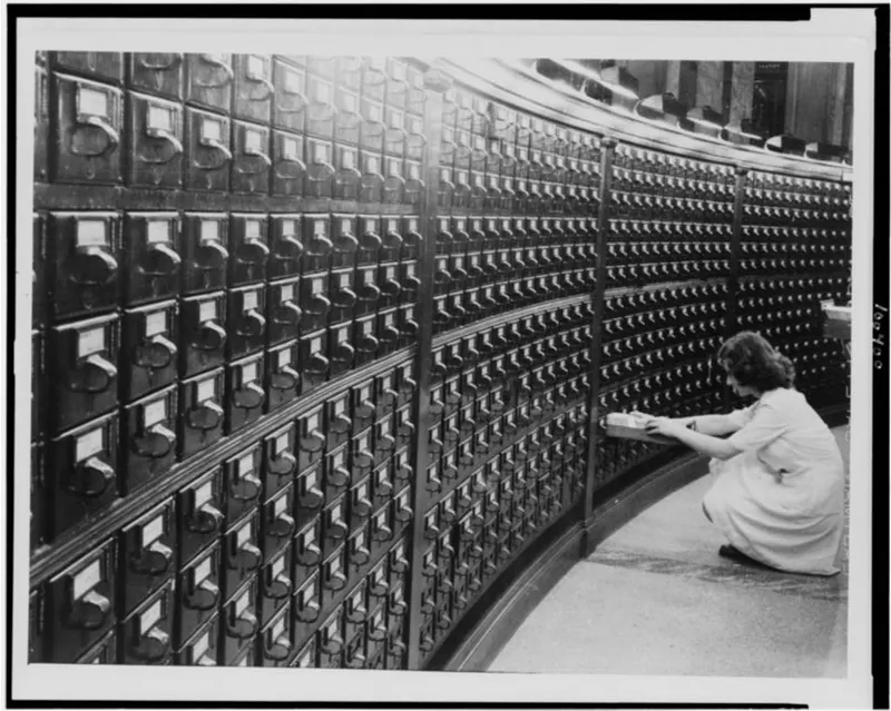 A woman using the card catalog in the Library of Congress Main Reading Room (c.1940), photographed by Jack Delano, representing the archive as a physical, material space before digitisation.